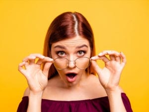 surprised woman pulling down glasses